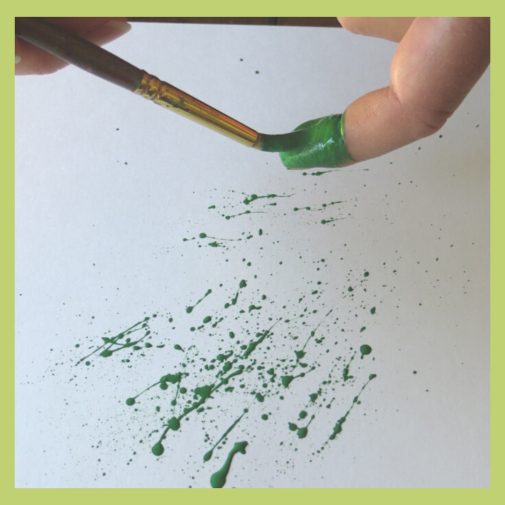Load your brush with paint and flick it across your index finger to create the splatters for your splattered paint art-myflowerjournal.com