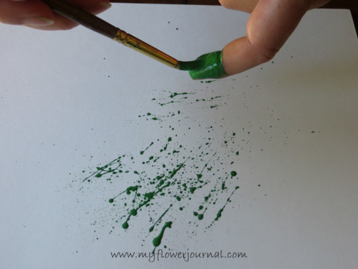 Load your brush with paint and flick it across your index finger to create the splatters for your splattered paint art-myflowerjournal.com
